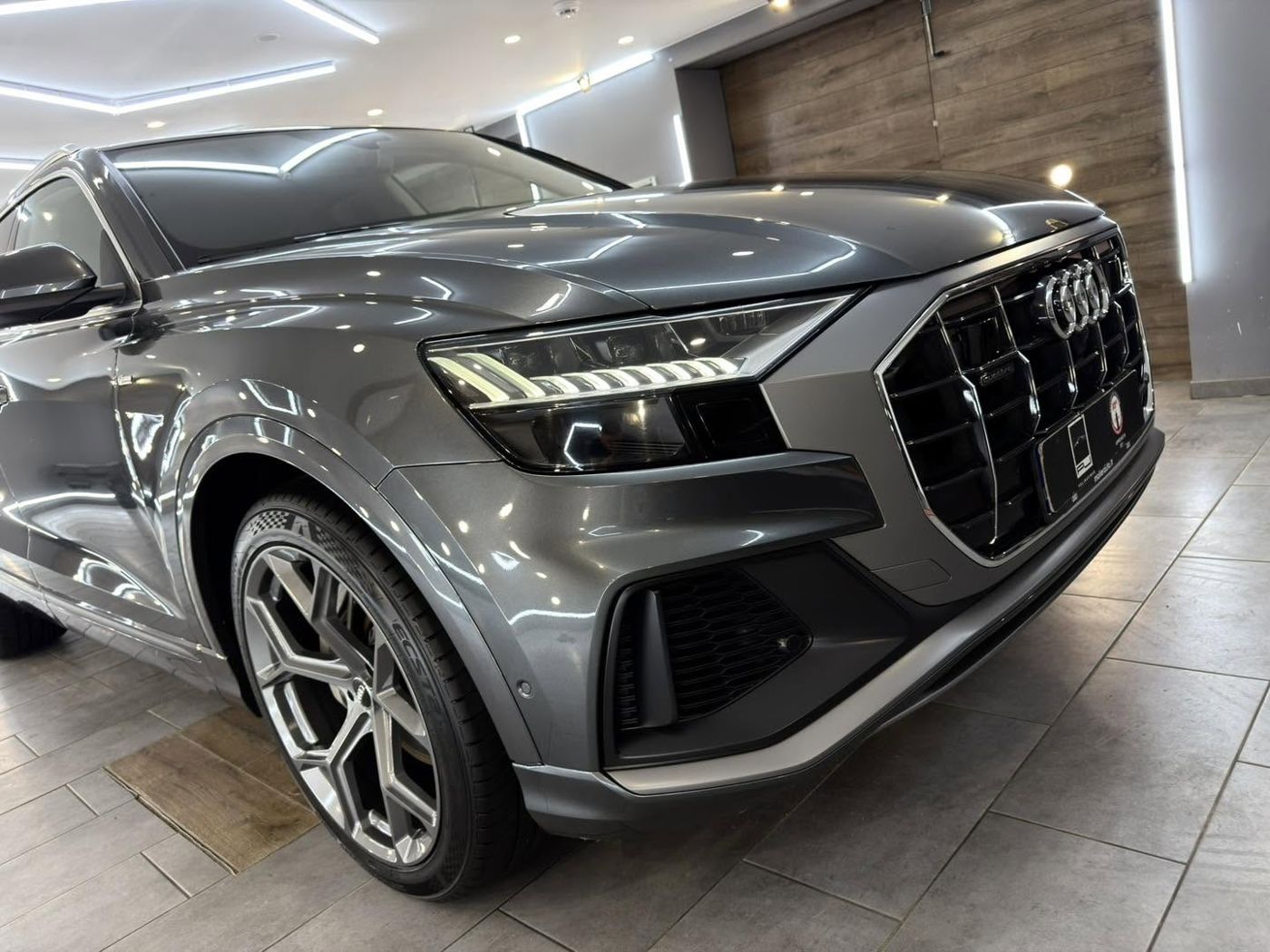 Pilkas Audi Q8 studijoje po poliravimo